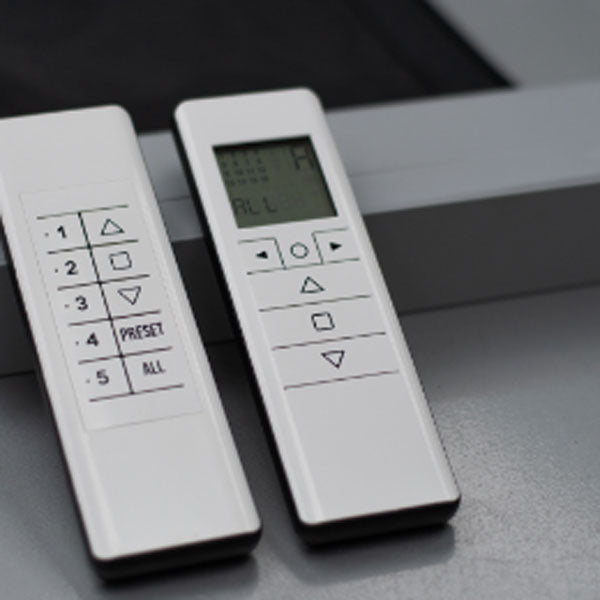 Two handheld remote controls used to raise and lower motorized screens.